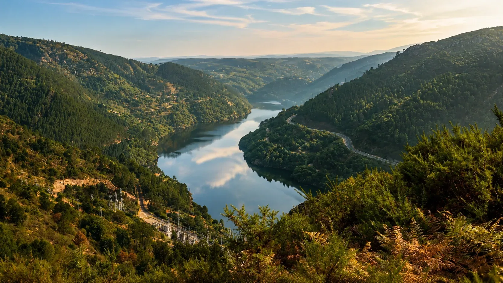 Panoramic miradouro viewpoint over the Douro Valley — the sweeping view from Casal de Loivos or São Leonardo da Galafura across the UNESCO terraced vineyards, the Douro River curving through the valley floor, and the distant ridgelines of the Serra do Marão in Northern Portugal