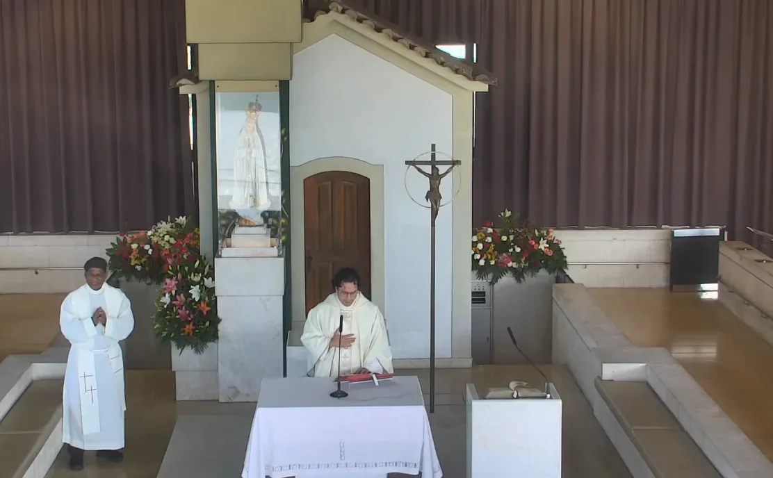 The Chapel of Apparitions at Fátima — the modern glass chapel marking the exact spot under an oak tree where the Virgin Mary appeared to Jacinta, Francisco, and Lúcia in 1917, surrounded by candles and flowers left by pilgrims