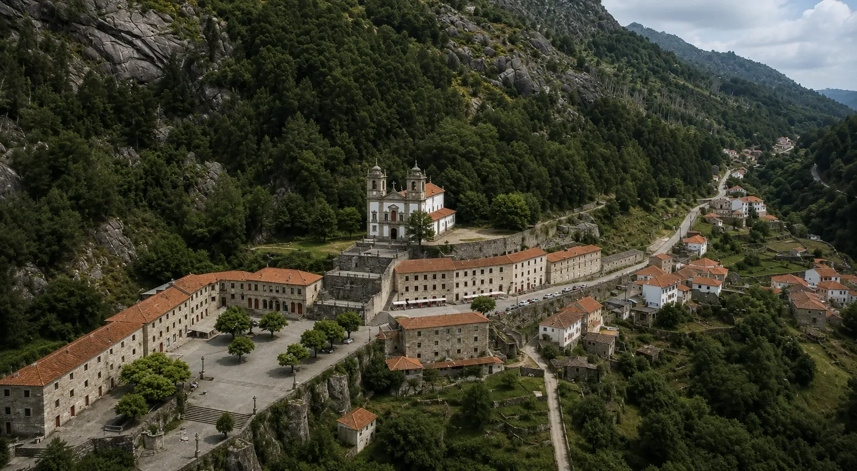 The traditional granite schist village of Ermida or Padroso in Peneda-Gerês National Park — ancient stone houses built from local granite with slate roofs, terraced vegetable gardens, stone water channels, and communal fountains unchanged for centuries, set against the forested mountain slopes of Portugal's only national park in the Minho highlands