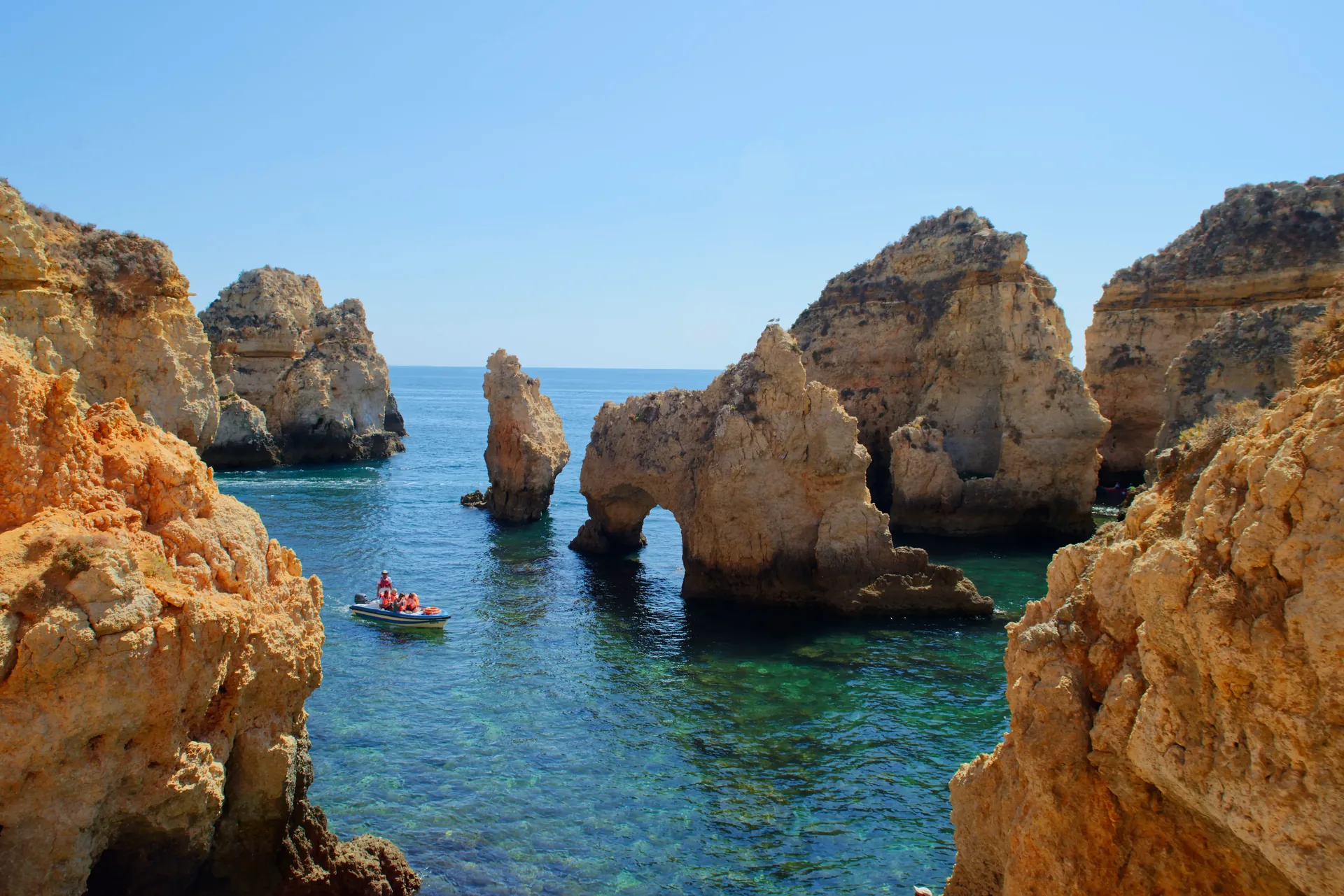 Ponta da Piedade golden limestone sea arches rising from turquoise Atlantic water — the spectacular eroded rock formations, sea caves and grottos at the tip of the Lagos headland in the western Algarve, one of the most photographed coastal landscapes in Portugal