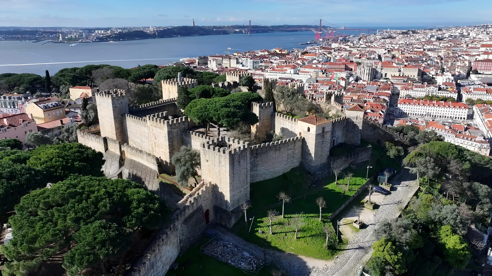 São Jorge Castle (Castelo de São Jorge) rising above Lisbon's terracotta rooftops — the 11th-century Moorish citadel with sweeping panoramic views over the Alfama district, the Tagus River, and Lisbon's historic centre, visited on a private full-day Lisbon tour