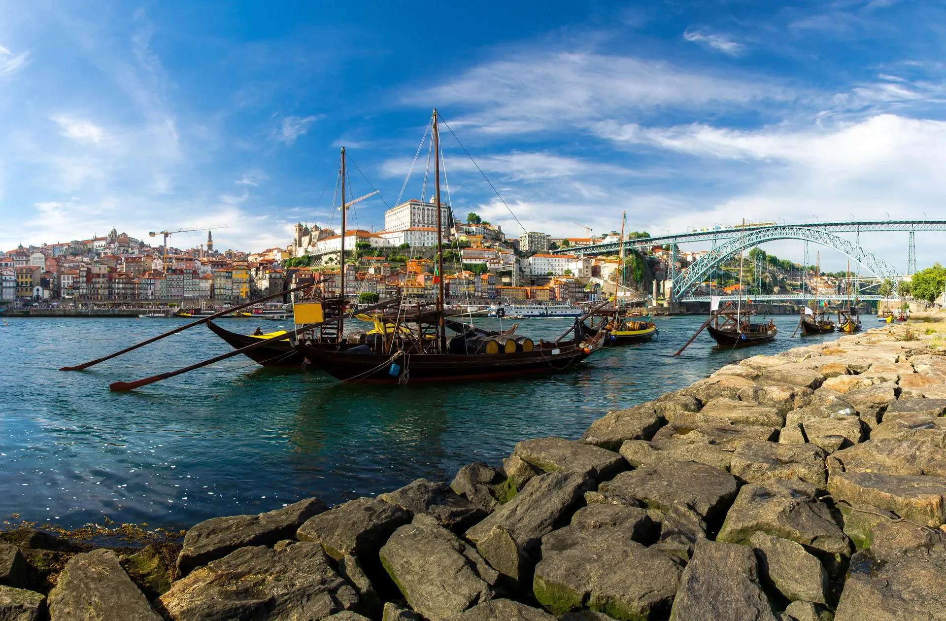 Ribeira waterfront at dusk with Dom Luís I Bridge behind — Porto's iconic UNESCO-listed riverside quarter with colourful 18th-century merchant houses, granite quays and the double-deck iron bridge spanning the Douro to Vila Nova de Gaia