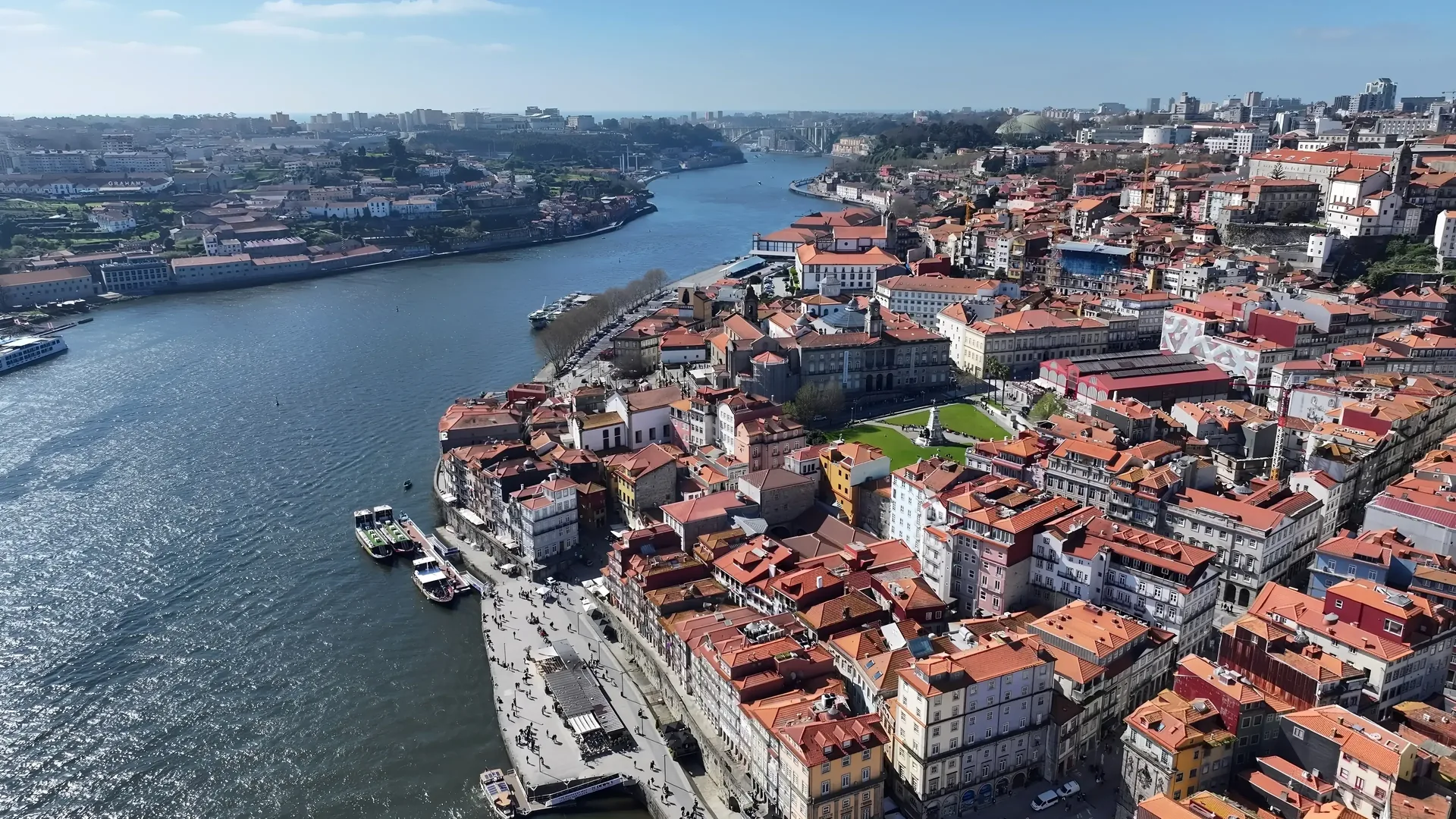 Vila Nova de Gaia and the port wine lodge terraces on the south bank of the Douro — the hillside lined with the famous lodge names and terrace restaurants overlooking the river, with the Ribeira quarter and Dom Luís I Bridge in the background