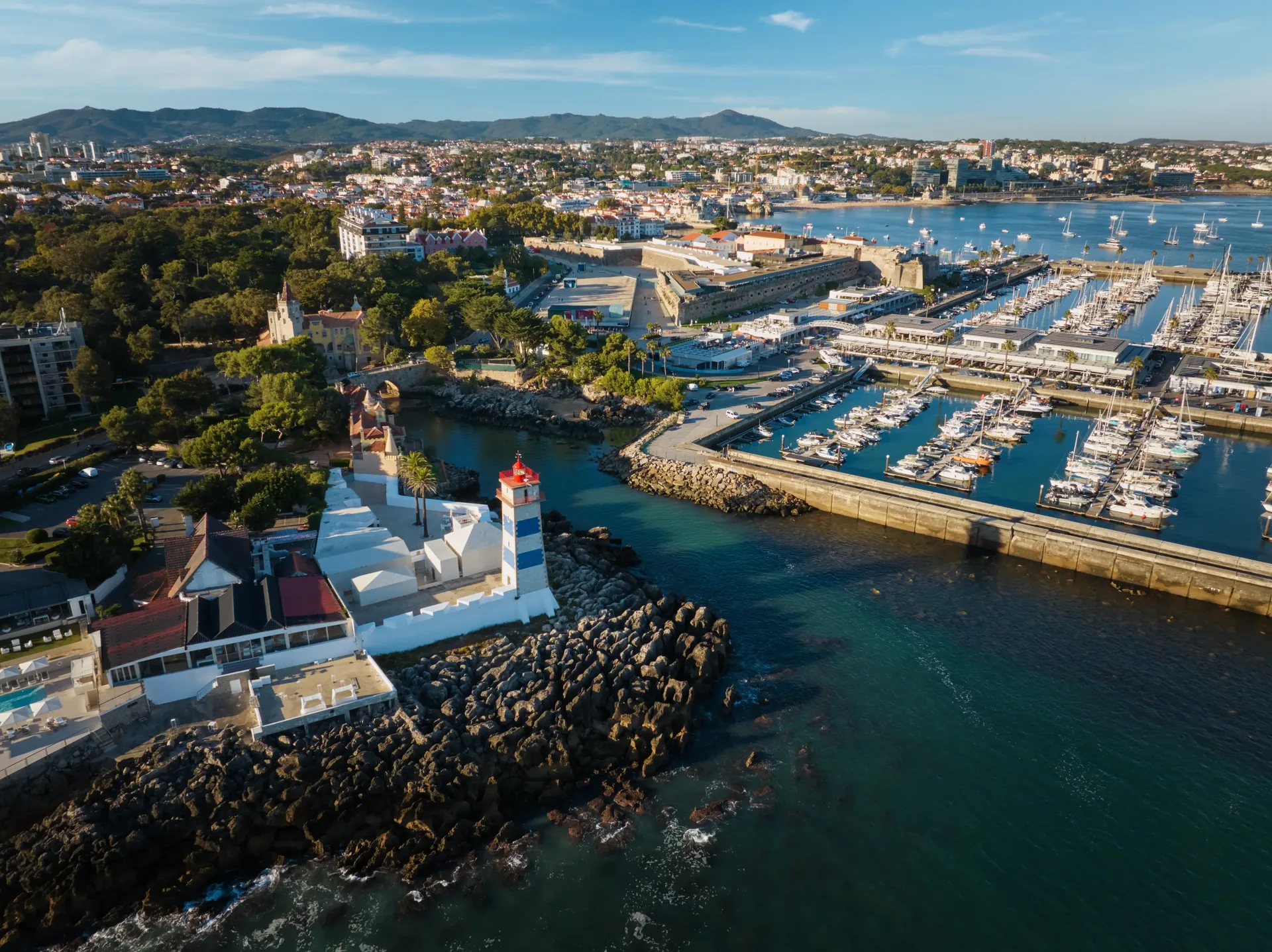 Cascais marina on the Atlantic Estoril coast west of Lisbon — the charming 19th-century fishing village turned aristocratic riviera town, with its whitewashed old town, yacht harbour, and golden stone promenade
