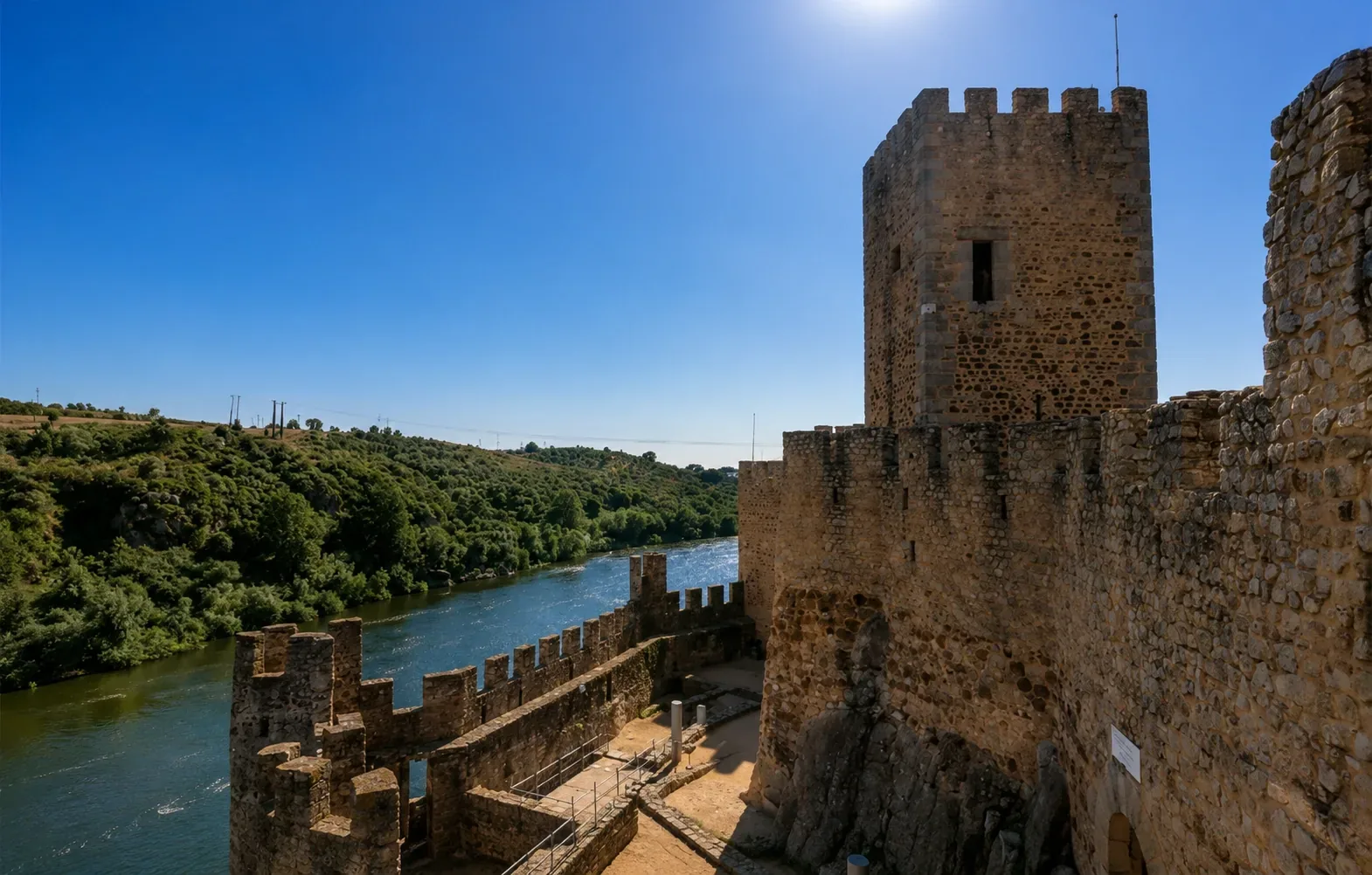 The towers and keep of Almourol Castle — the battlemented walls and circular towers of the 12th-century Templar fortress rising from its river island against the backdrop of the Tagus valley, a perfectly preserved example of Templar military architecture