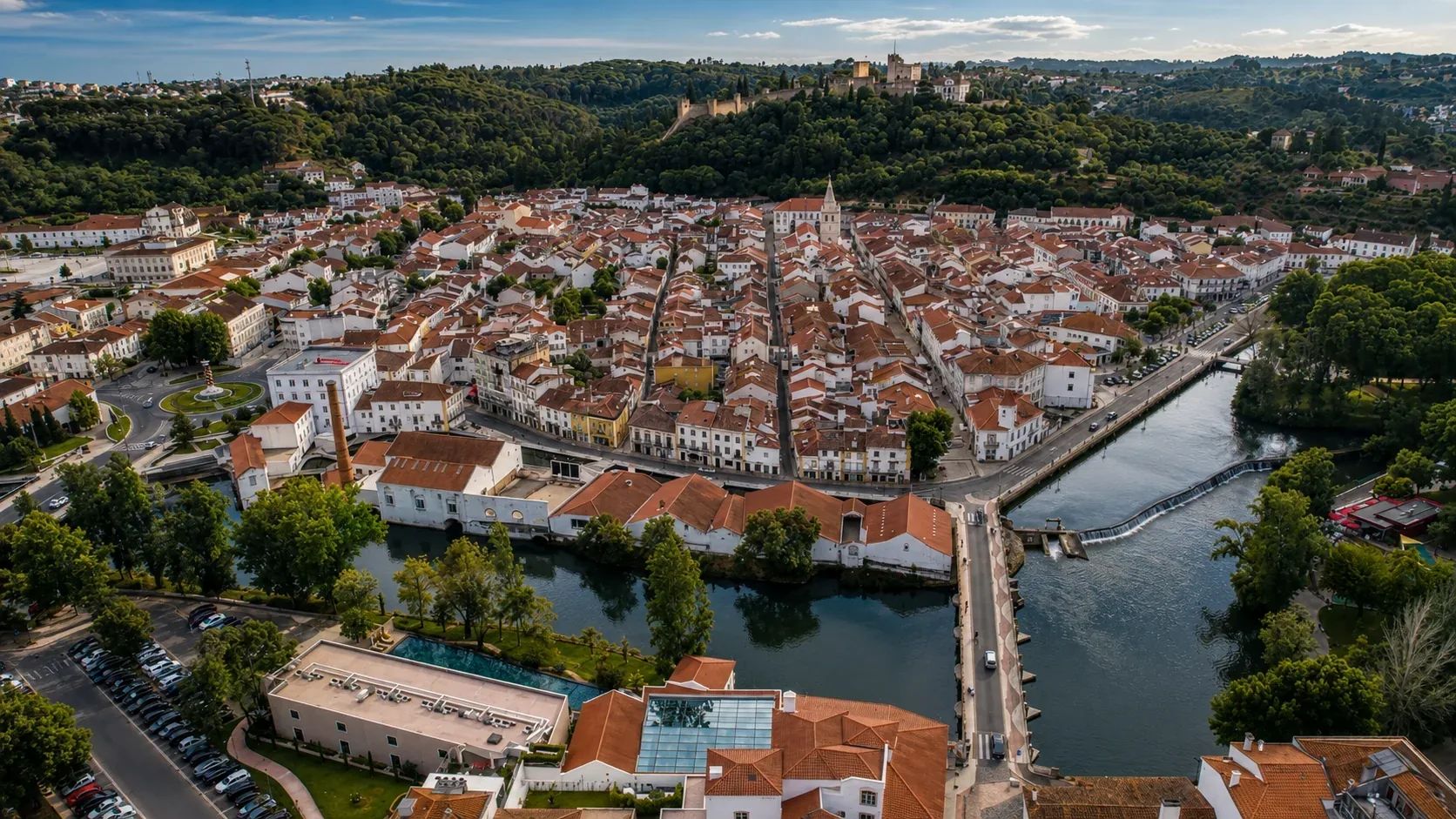 Tomar's medieval town centre — cobbled streets leading past the Church of São João Baptista with its distinctive Manueline tower and the traditional Portuguese white and terracotta buildings of one of Portugal's most intact medieval market squares