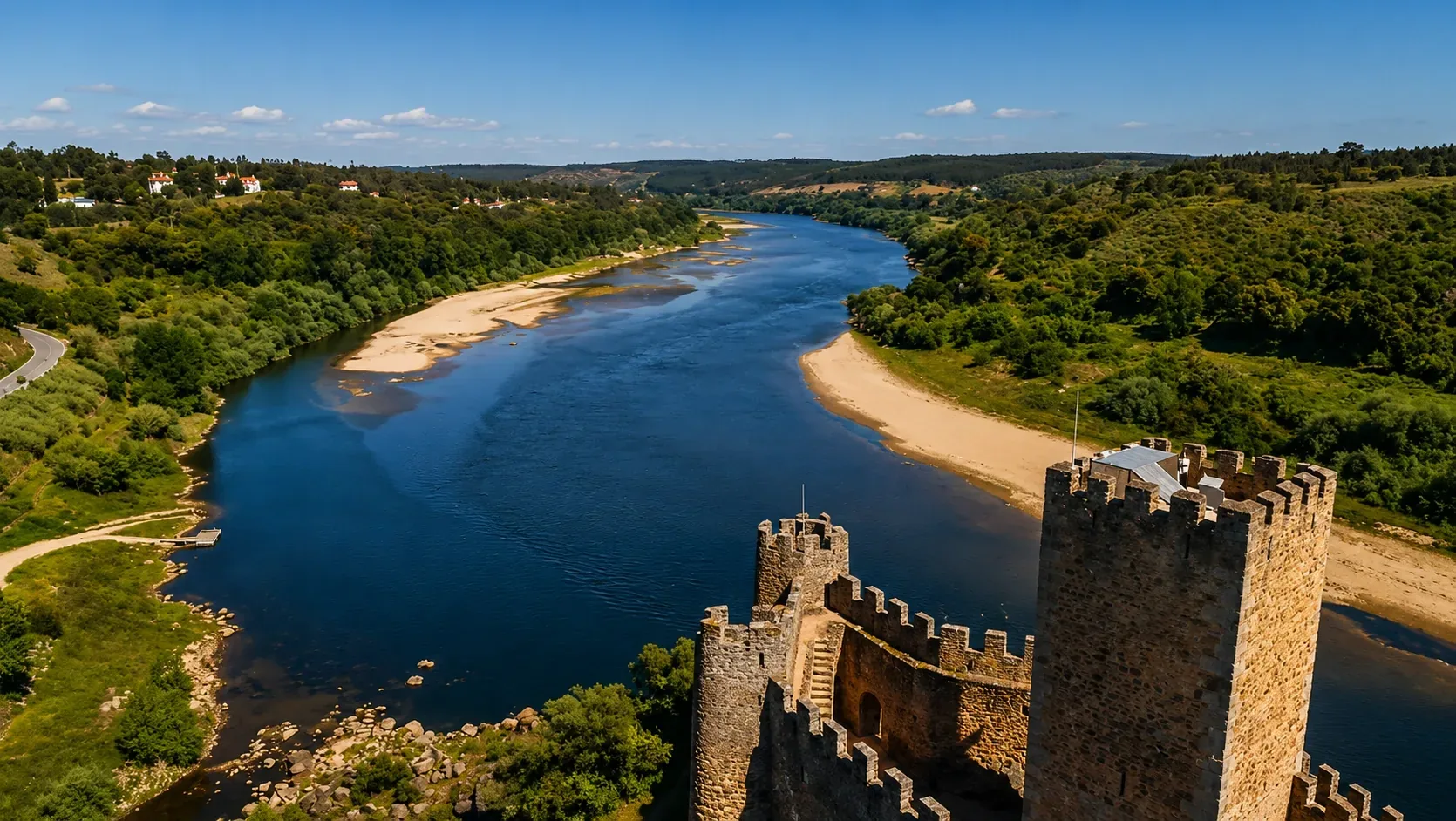 Panoramic view of the River Tagus valley near Almourol — the wide, calm river winding through wooded hills and Ribatejo farmland, one of the most beautiful river landscapes in central Portugal